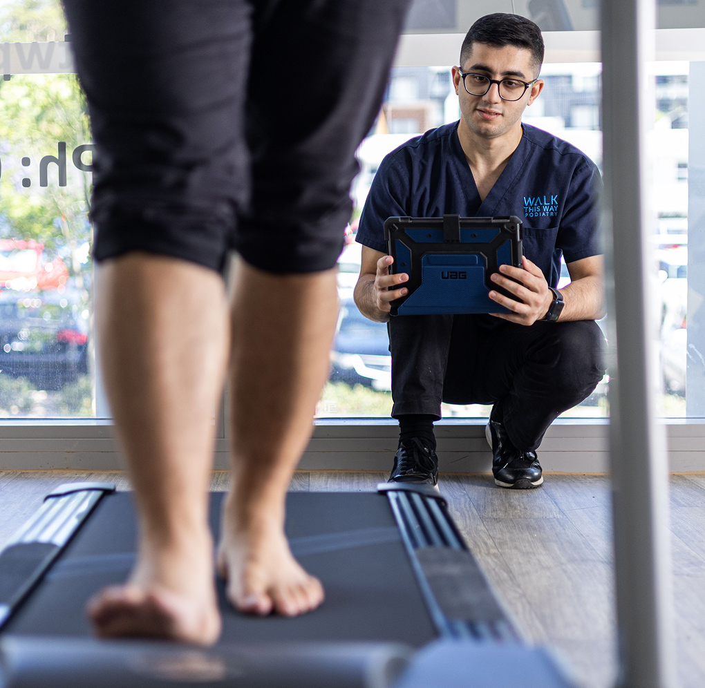 Podiatrist performing gait analysis for orthotics prescription