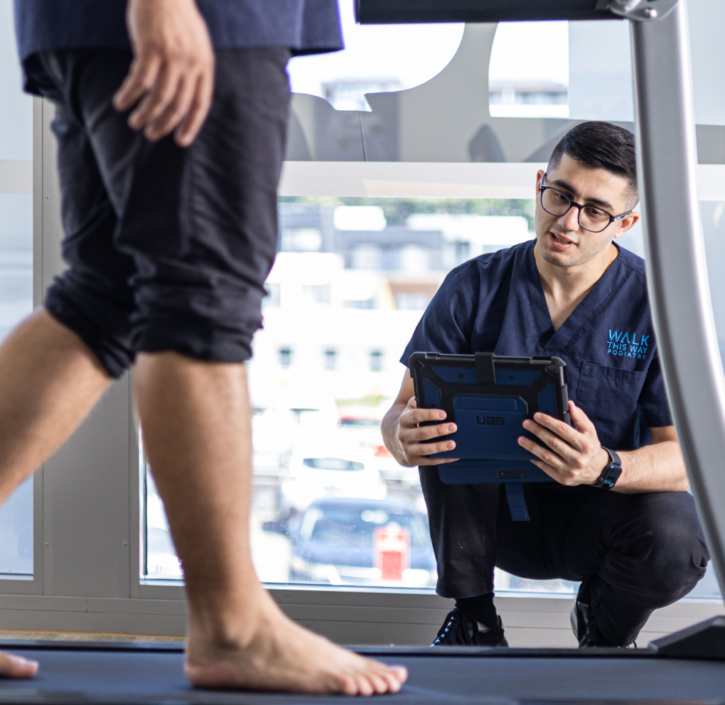Podiatrist performing gait analysis for orthotics prescription